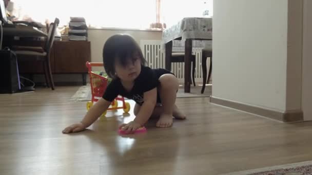 房间里的孩子提着一辆婴儿车 在路上 他丢失了她的玩具 把掉在车上的玩具捡起来 — 图库视频影像