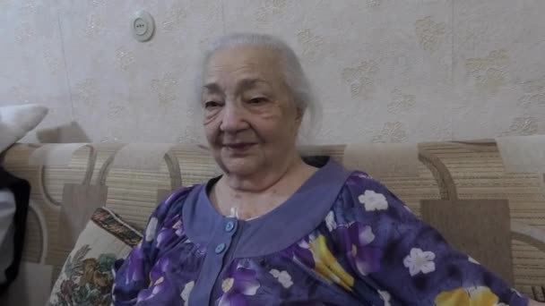 Een Oude Vrouw Een Badjas Zit Bank Zoek Naar Iets — Stockvideo