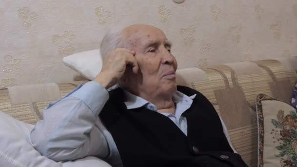 Γέρος Χαμογελάει Χαρούμενος Στον Καναπέ Ακουμπώντας Ένα Μαξιλάρι Γυρίζει Κεφάλι — Αρχείο Βίντεο