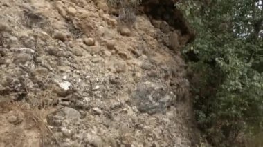 Dağ yamacı. Değişen büyüklükteki kayalar dağ yolunda tehlikeli bir şekilde asılı duruyor.