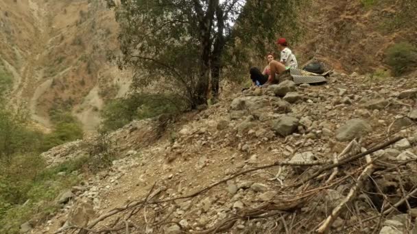 Um cara e uma menina são caminhantes em um local de descanso nas montanhas. — Vídeo de Stock