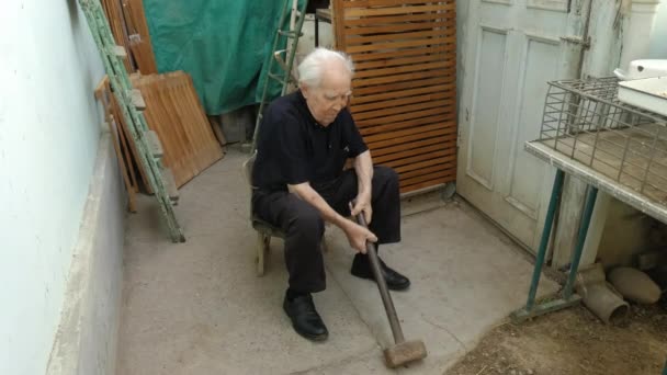 Un abuelo está tratando de levantar un martillo.. — Vídeos de Stock