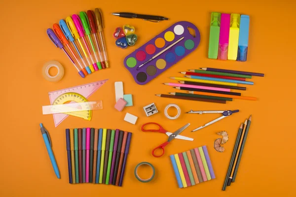 Fournitures scolaires sur fond orange — Photo