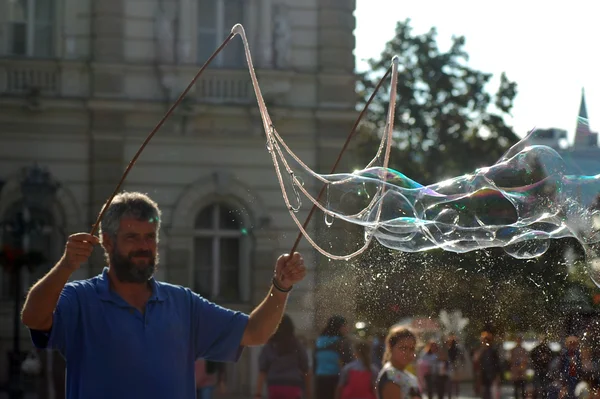 Man makes big bubbles on the street — Stock Photo, Image