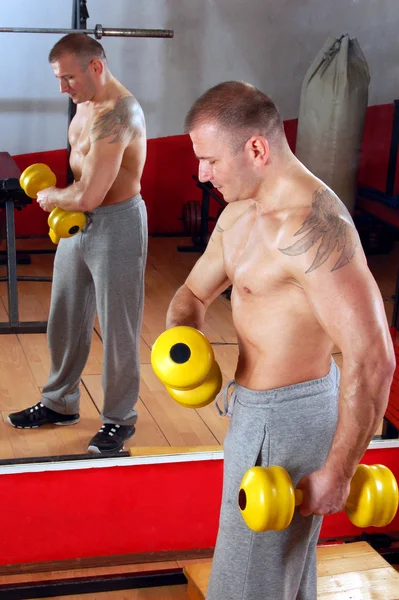 Man is looking at himself at the gym — Stockfoto