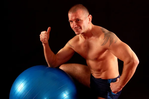 Hombre con pilates bola muestra bien —  Fotos de Stock