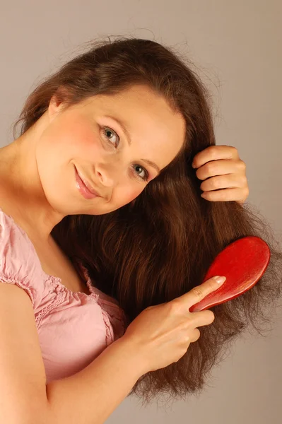 Souriant femme est peigner ses cheveux — Photo