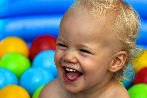 Laughing child with colorful balls Stock Picture