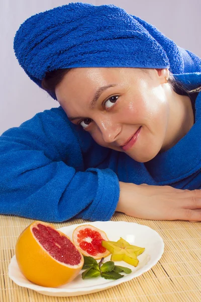 Woman in blue towel with fruits — Stock Photo, Image
