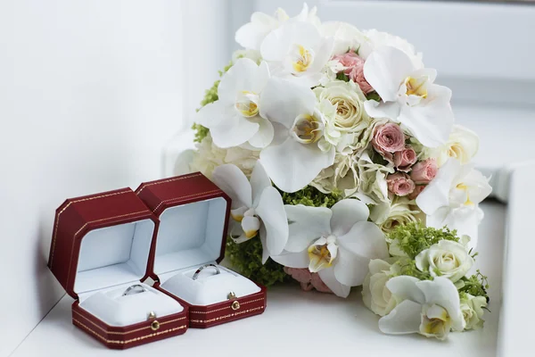 Anillos de boda en una caja cerca de un ramo de bodas —  Fotos de Stock