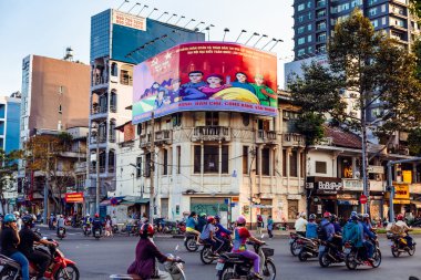HO CHI MINH, VIETNAM - JAN 14, 2016: Architecture and motorbikes traffic on the street in Hochiminh (Saigon) on the sunset. Saigon is the largest city in Vietnam