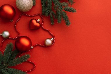 Kırmızı topları ve kırmızı arkaplanı olan Noel süslemeleri