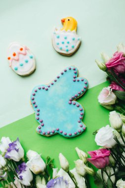 Paskalya kurabiyesi ve çiçekler masada.