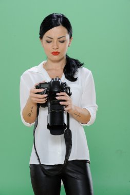 Bir dijital Slr fotoğraf makinesi tutan mutlu bir genç kadın portresi. Dikey vurdu. Yeşil renk arka plan üzerinde izole