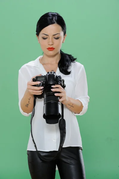 Bir dijital Slr fotoğraf makinesi tutan mutlu bir genç kadın portresi. Dikey vurdu. Yeşil renk arka plan üzerinde izole — Stok fotoğraf