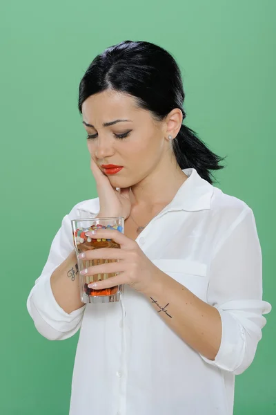 Mujer sosteniendo una pastilla y un vaso de agua en la mano — Foto de Stock