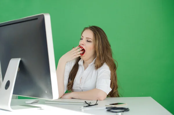 Tired young businesswoman working with computer on green screen — Stock Photo, Image