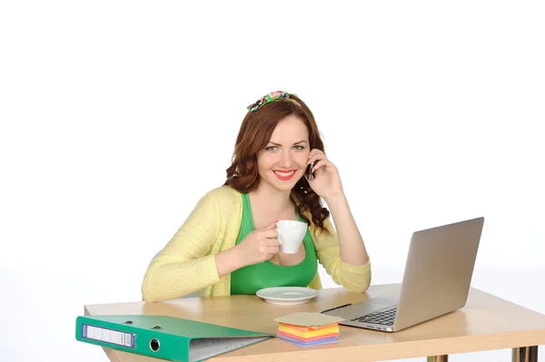 Feliz joven mujer exitosa que trabaja en el escritorio con ordenador portátil y teléfono móvil aislado en blanco — Foto de Stock