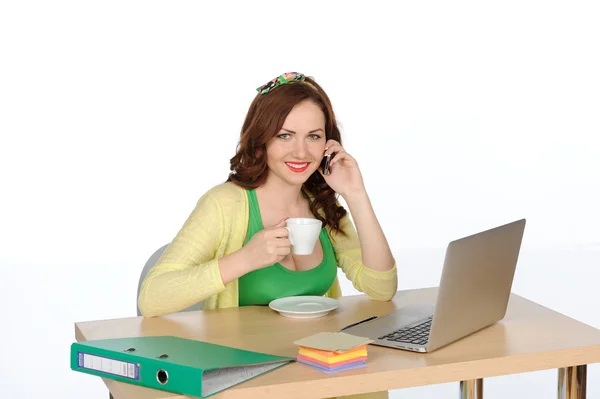 Happy young successful woman working at desk with laptop and mobile phone isolated on white — Stock Photo, Image