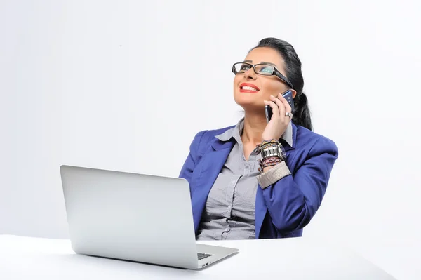 Mulher bonita sentada na mesa do escritório e falando no telefone celular isolado no fundo branco — Fotografia de Stock