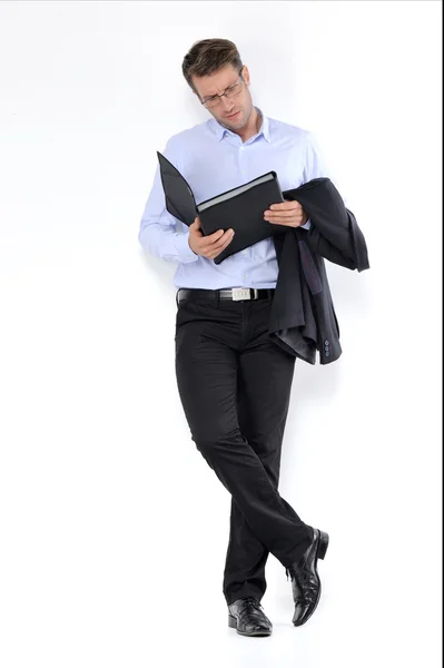 Joven hombre guapo en traje negro y gafas sonriendo aislado sobre fondo blanco — Foto de Stock