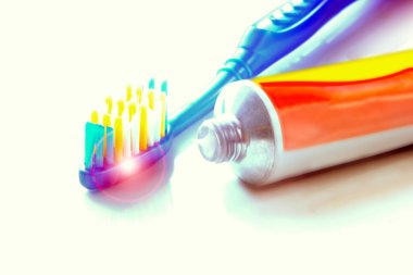 Mavi diş fırçası diş macununun yanında, beyaz arka planda yakın plan, diş temizleme, sağlıklı yaşam tarzı