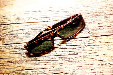 light-protective glasses on the textured surface of the old wooden table