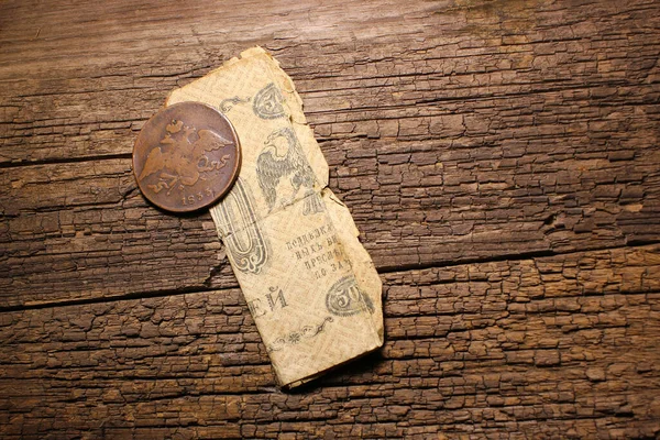 Wallet and old money coins of Russian empire on wooden table background.