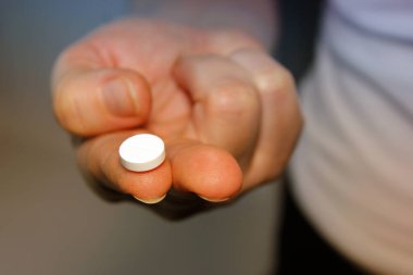 Bir kadının avucundaki haplar uykusuz gece kavramının bir aracı olarak karanlık bir arkaplanı kapatır.