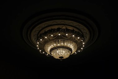 İç kısımda tavandan sarkan yuvarlak şekilli güzel bir kristal avizeye yakın plan.