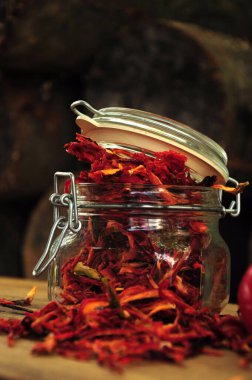 Taze biberli Paprika. Ahşap bir arka planda cam bir kavanozda kurutulmuş biber. Dondurulmuş sebzeler. Yemek kırmızıdır. Kurutulmuş baharatlar sağlıklı yiyecekler. Baharatlar.