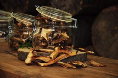 Ahşap bir arka planda cam bir kavanozda kurutulmuş mantar. Dondurulmuş sebzeler. Kurutulmuş baharatlar sağlıklı yiyecekler. Baharatlar.