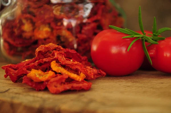 Sun-dried tomatoes in a glass jar on a wooden background.  Sun-dried Italian tomatoes. Freeze-dried vegetables. Dried spices healthy food. Spices.