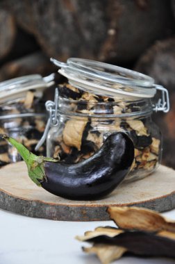 Ahşap bir arka planda cam bir kavanozda kurutulmuş patlıcan. Dondurulmuş sebzeler. Kurutulmuş baharatlar sağlıklı yiyecekler. Baharatlar.