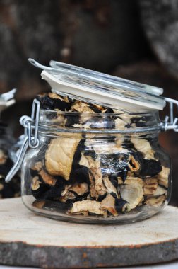 Ahşap bir arka planda cam bir kavanozda kurutulmuş patlıcan. Dondurulmuş sebzeler. Kurutulmuş baharatlar sağlıklı yiyecekler. Baharatlar.