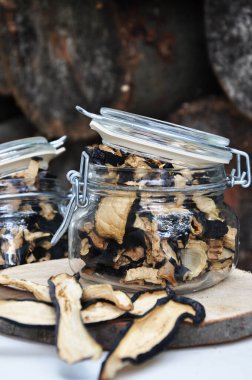 Ahşap bir arka planda cam bir kavanozda kurutulmuş patlıcan. Dondurulmuş sebzeler. Kurutulmuş baharatlar sağlıklı yiyecekler. Baharatlar.