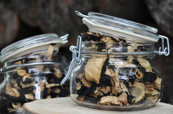 Ahşap bir arka planda cam bir kavanozda kurutulmuş patlıcan. Dondurulmuş sebzeler. Kurutulmuş baharatlar sağlıklı yiyecekler. Baharatlar.