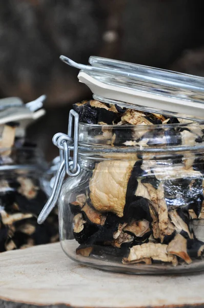 Ahşap bir arka planda cam bir kavanozda kurutulmuş patlıcan. Dondurulmuş sebzeler. Kurutulmuş baharatlar sağlıklı yiyecekler. Baharatlar.