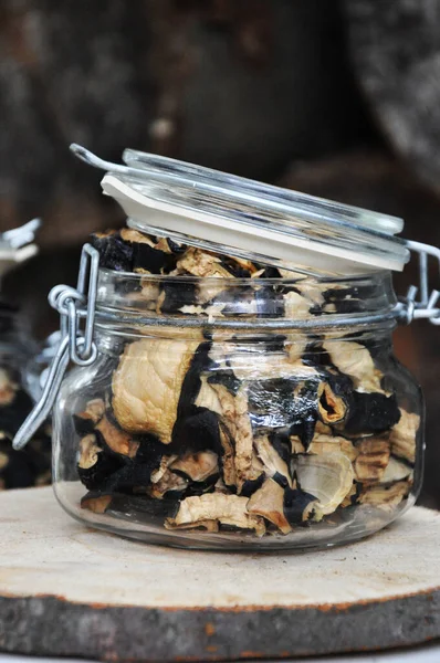 Ahşap bir arka planda cam bir kavanozda kurutulmuş patlıcan. Dondurulmuş sebzeler. Kurutulmuş baharatlar sağlıklı yiyecekler. Baharatlar.