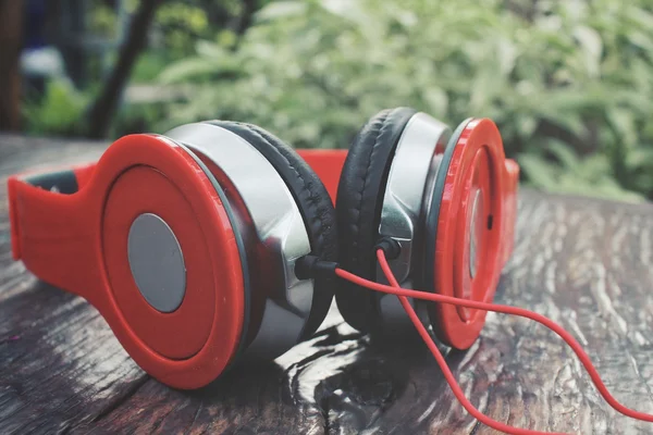 Fones de ouvido vermelhos no fundo de madeira — Fotografia de Stock