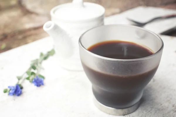 Café negro con flores moradas — Foto de Stock