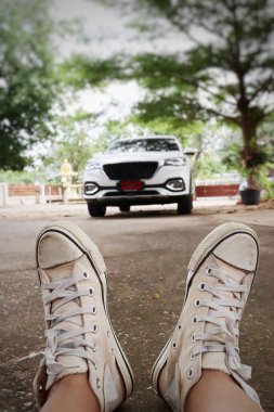 Beyaz spor ayakkabıların selfie 'si. Gençlik ve bulanık araba.
