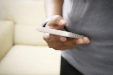 Blurred of woman playing smart phone on sofa from home