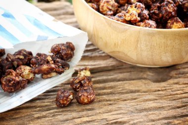 Chocolate covered popcorn and paper bag on wood table