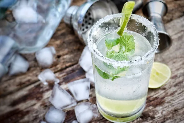 Making a margarita cocktail lime salt and mint leaves