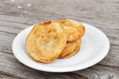 Tahta masa arkasındaki tabakta Kore usulü krep var.