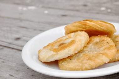 Tahta masa arkasındaki tabakta Kore usulü krep var.