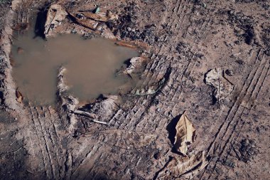 Toprak yol arkaplanındaki tekerlek izleri veya desen J1 ayarlı VSCO ile işlendi