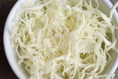 Ahşap masa arkasında doğranmış taze lahana Çin sebzesi.