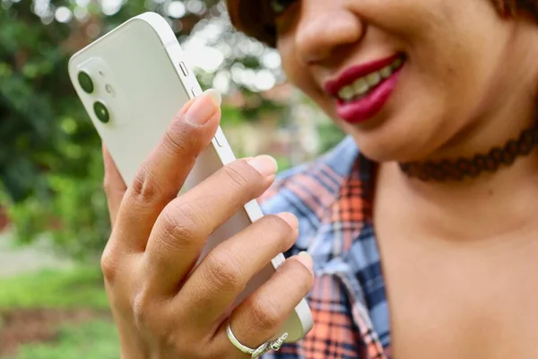 Portrait of Asia woman using smart phone on hand and tropical leaves